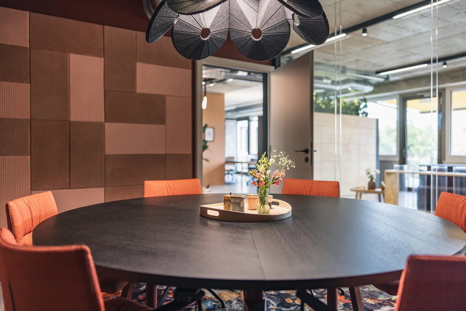 Runder Tisch mit orangen Stühlen im Besprechungsraum der Work Factory